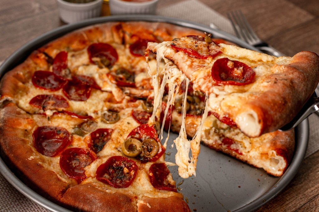 Fresh pepperoni pizza with cheese pull at Urban Crust Pizza & Grill, Brooklyn NY